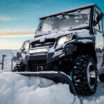 Štvorkolka vybavená zimnými doplnkami, pripravená na využitie v snehu a mraze.