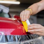 Auto s opravovanými preliačinami, ilustrujúce dôležitosť včasnej údržby a opravy karosérie.