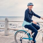 Dospelý cyklista nasadá na bicykel na lesnej ceste po dlhšej prestávke.