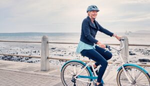 Dospelý cyklista nasadá na bicykel na lesnej ceste po dlhšej prestávke.