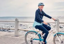 Dospelý cyklista nasadá na bicykel na lesnej ceste po dlhšej prestávke.